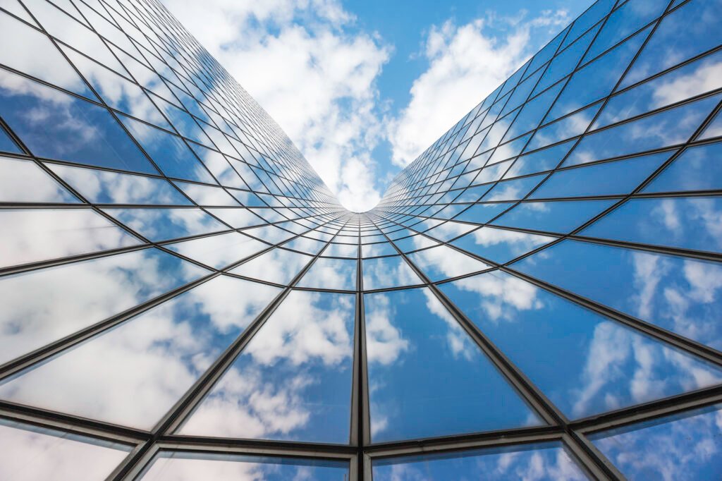 Blue sky and white clouds reflecting in a glass building