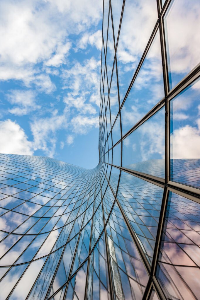 Blue sky and white clouds reflecting in a glass building
