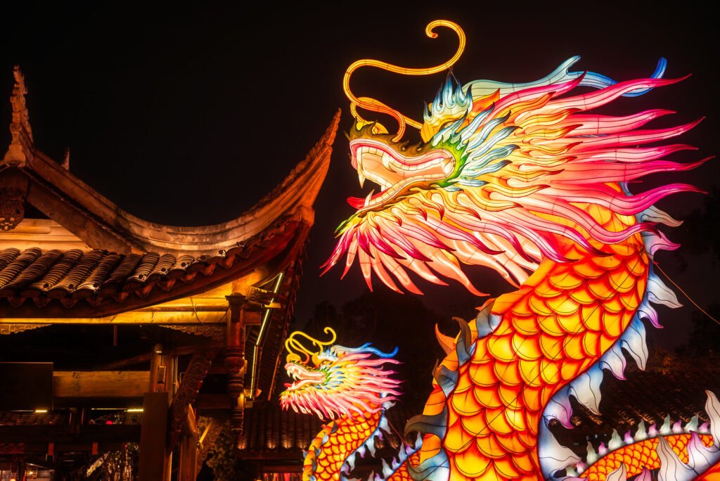 Dragon lanterns illuminated at night with red Chinese lanterns