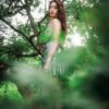 Portrait of a beautiful woman wearing a silver dress standing in a forest
