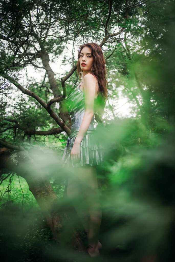 Portrait of a beautiful woman wearing a silver dress standing in a forest