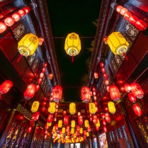 Red and yellow Chinese lanterns with Sichuan opera faces illuminated at night