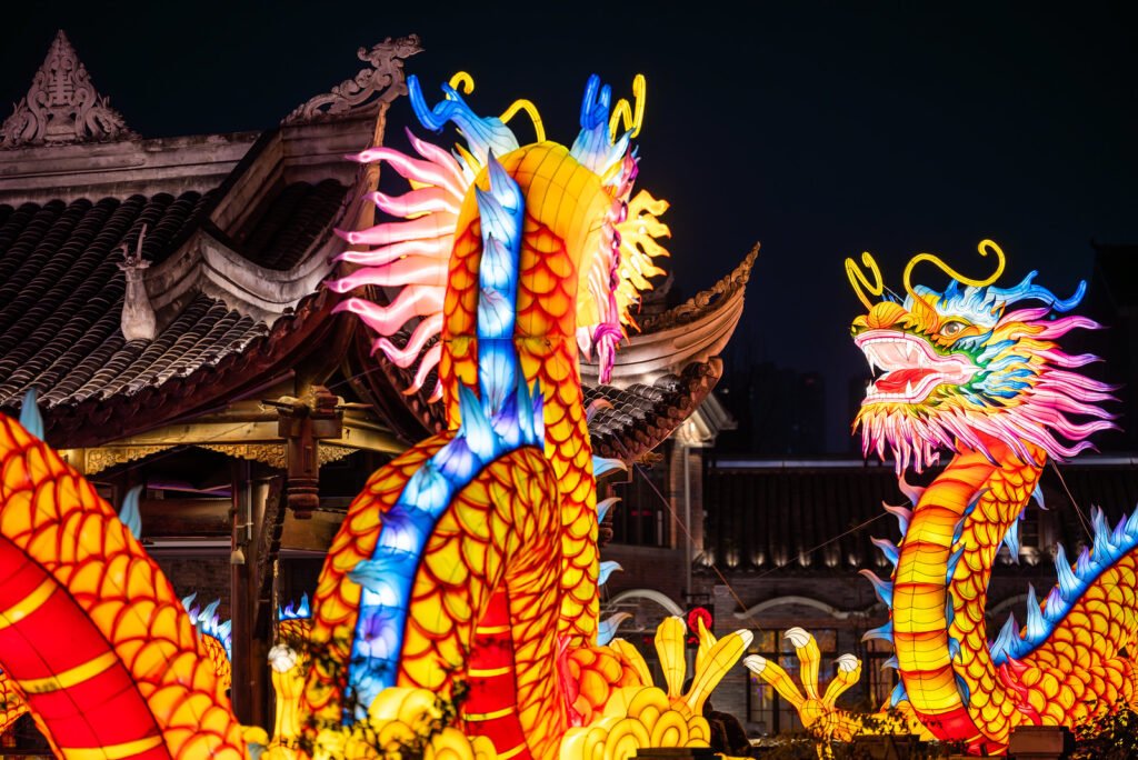 Dragon lanterns illuminated at night with red Chinese lanterns