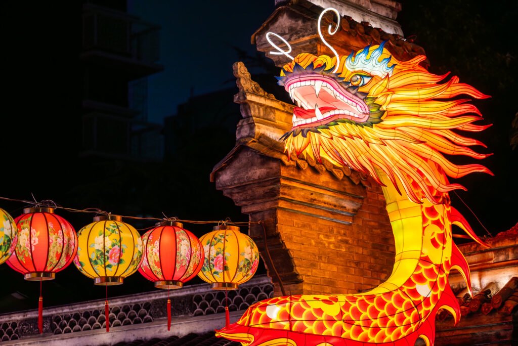 Dragon lanterns illuminated at night with red Chinese lanterns