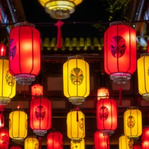 Red and yellow Chinese lanterns with Sichuan opera faces illuminated at night