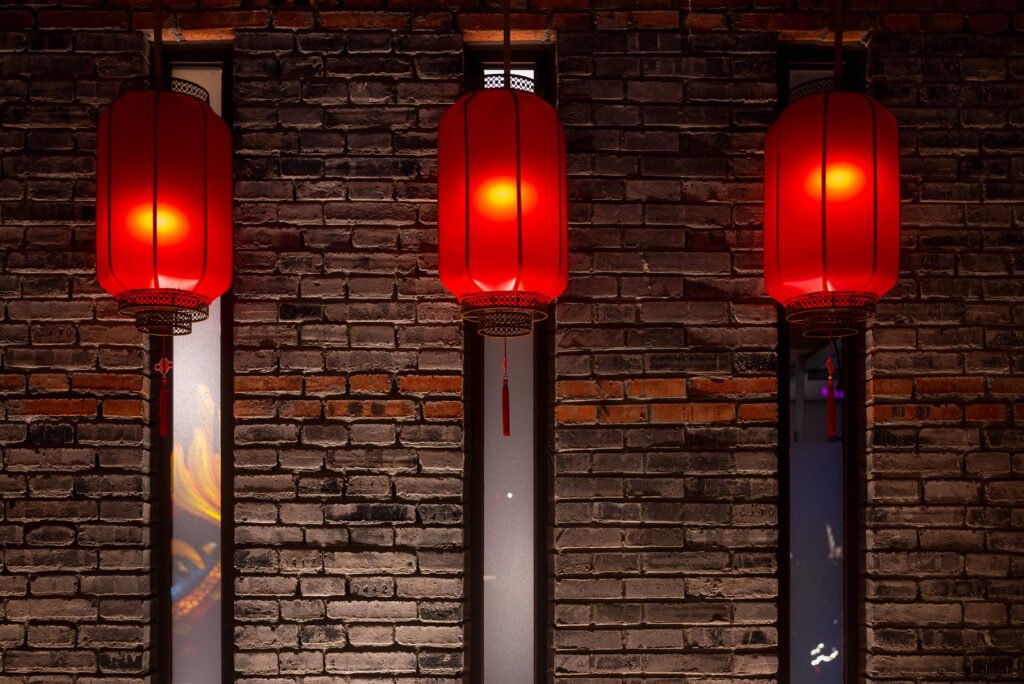 Red Chinese lanterns against brick wall at night