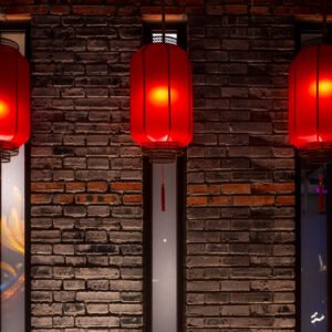 Red Chinese lanterns against brick wall at night