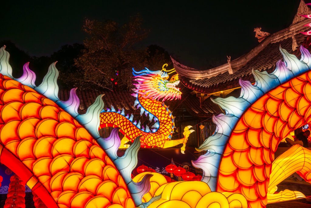 Dragon lanterns illuminated at night with red Chinese lanterns