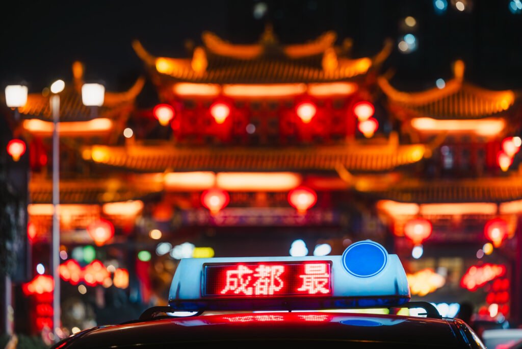 Qintalilu Chinese traditional gate illuminated at night with a taxi in the foreground