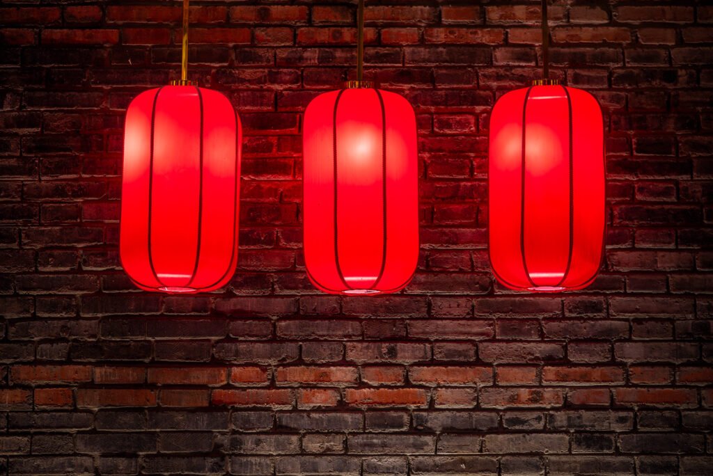 Red Chinese lanterns against brick wall at night