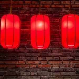 Red Chinese lanterns against brick wall at night