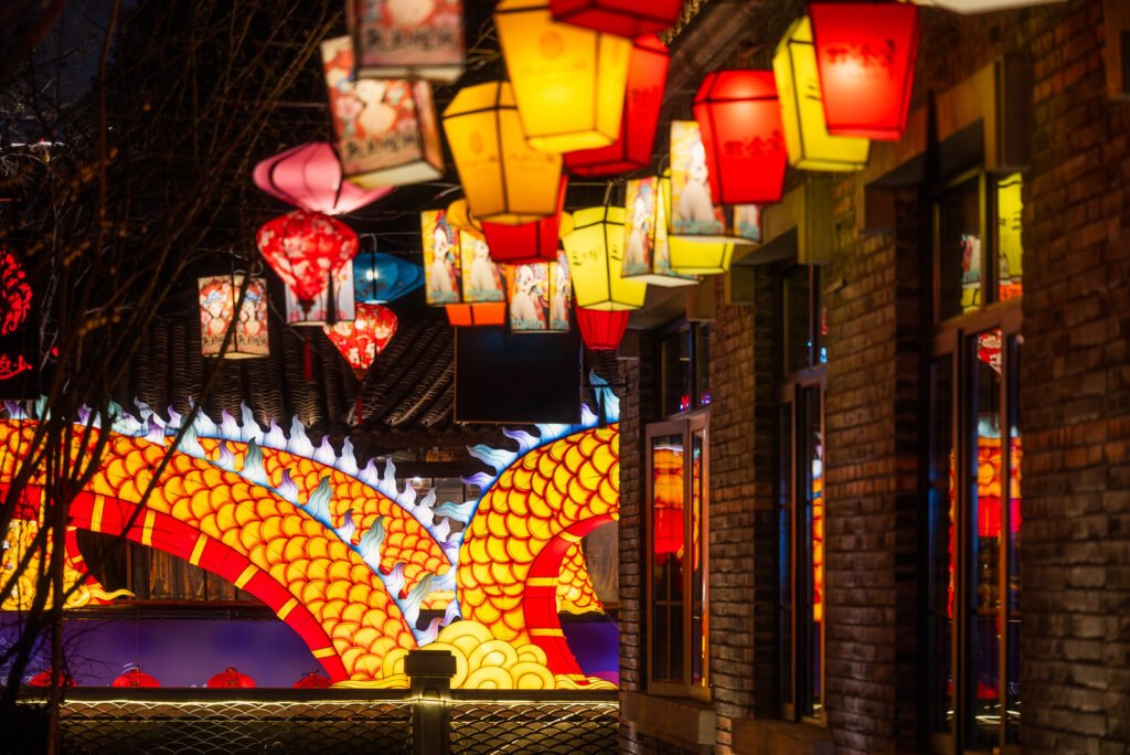 Dragon lanterns illuminated at night with red Chinese lanterns