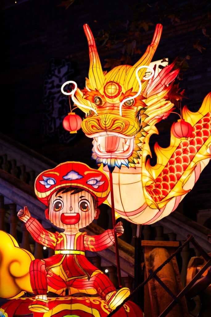Dragon lanterns illuminated at night with red Chinese lanterns