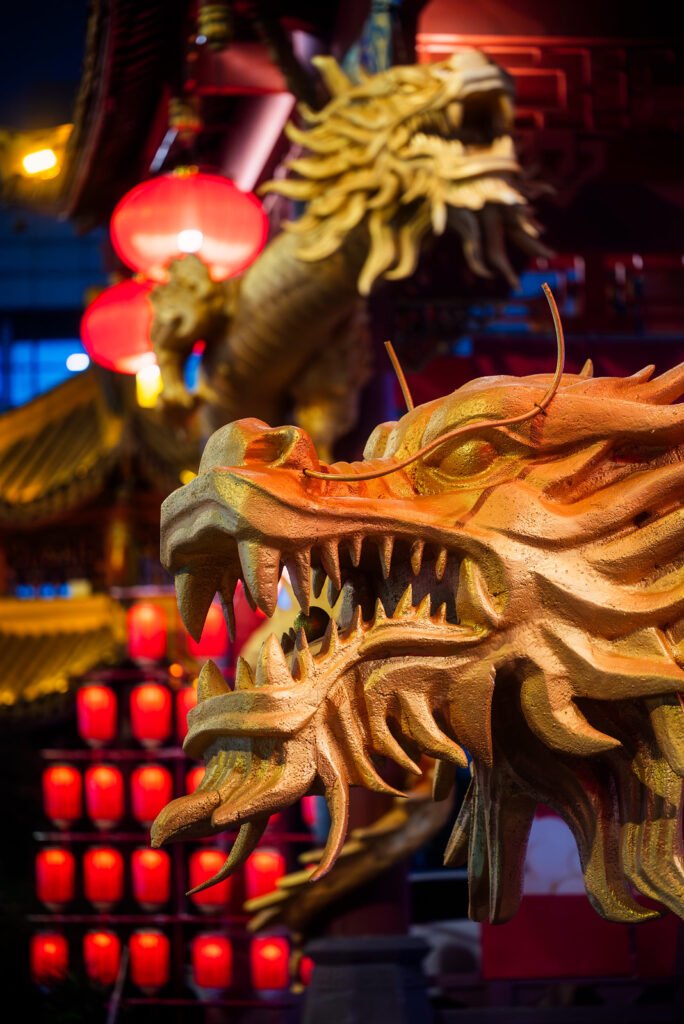 Dragon sculptures illuminated at night with red Chinese lanterns