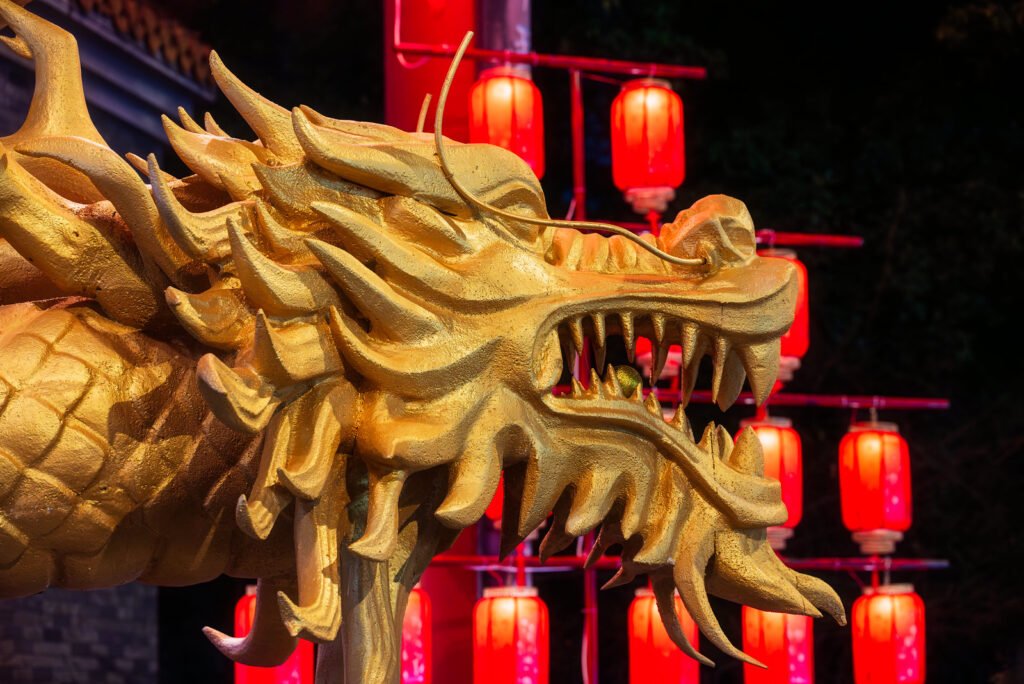 Dragon sculpture illuminated at night with red Chinese lanterns