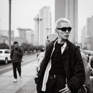 Young Asian man wearing sunglasses and a stylish outfit in the city.