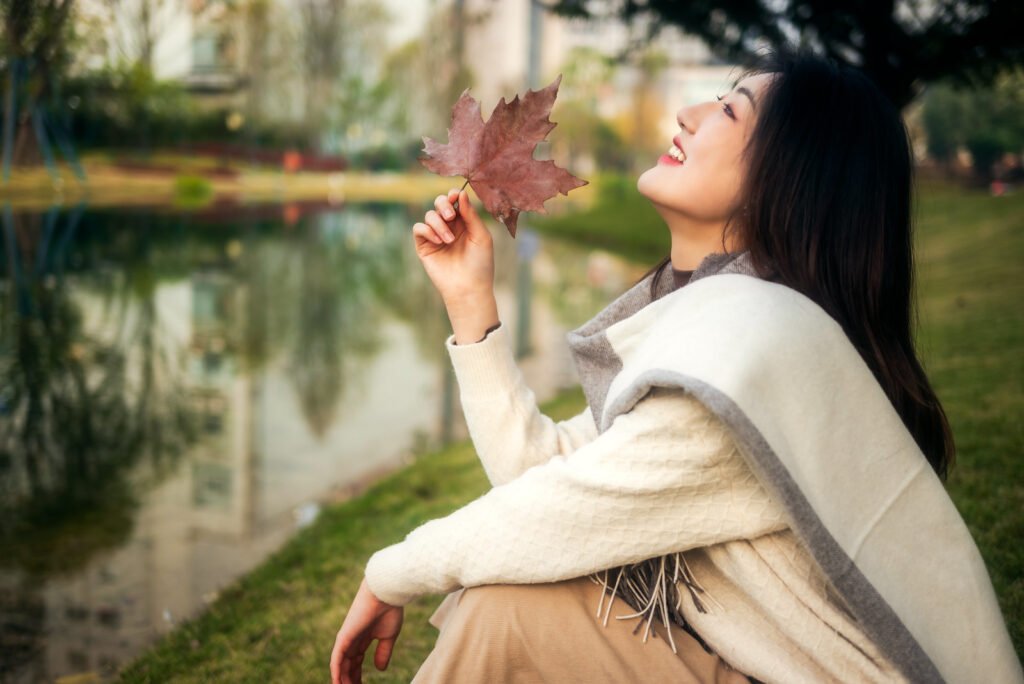 A Young Woman Sitting by the lake in Autumn