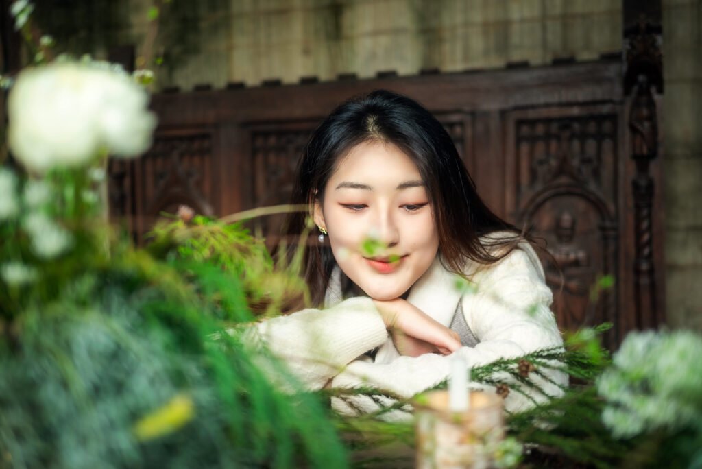Thoughtful young woman looking at a beautiful flower arrangement.