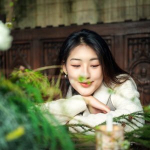 Thoughtful young woman looking at a beautiful flower arrangement.