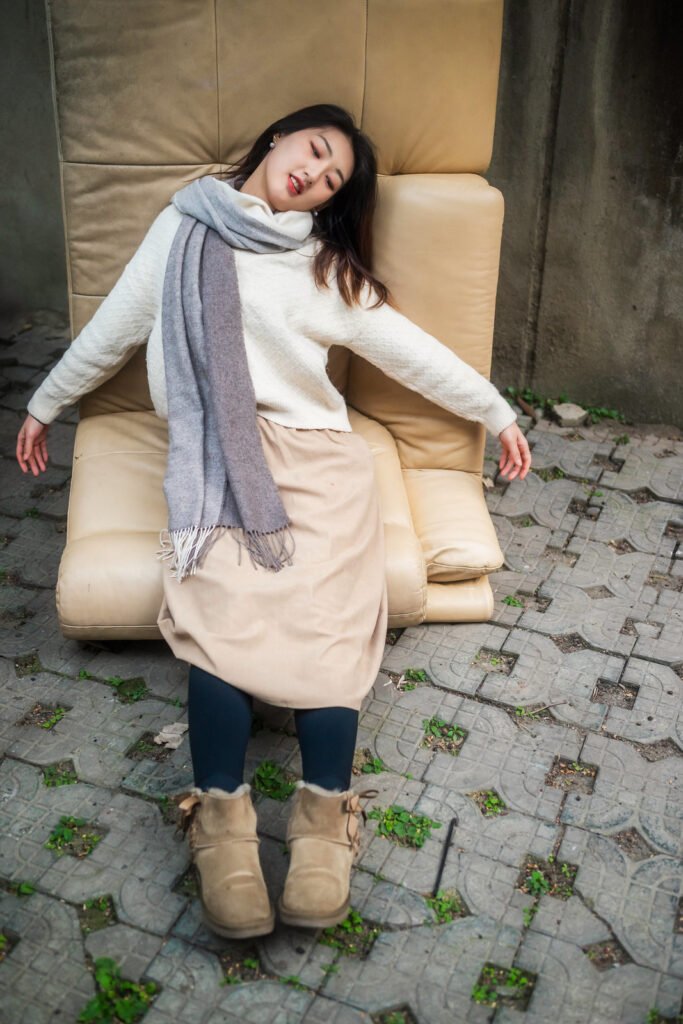 Young woman sitting on a couch outdoors.