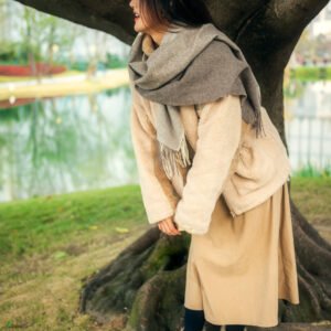 Portrait of a young woman standing by a tree