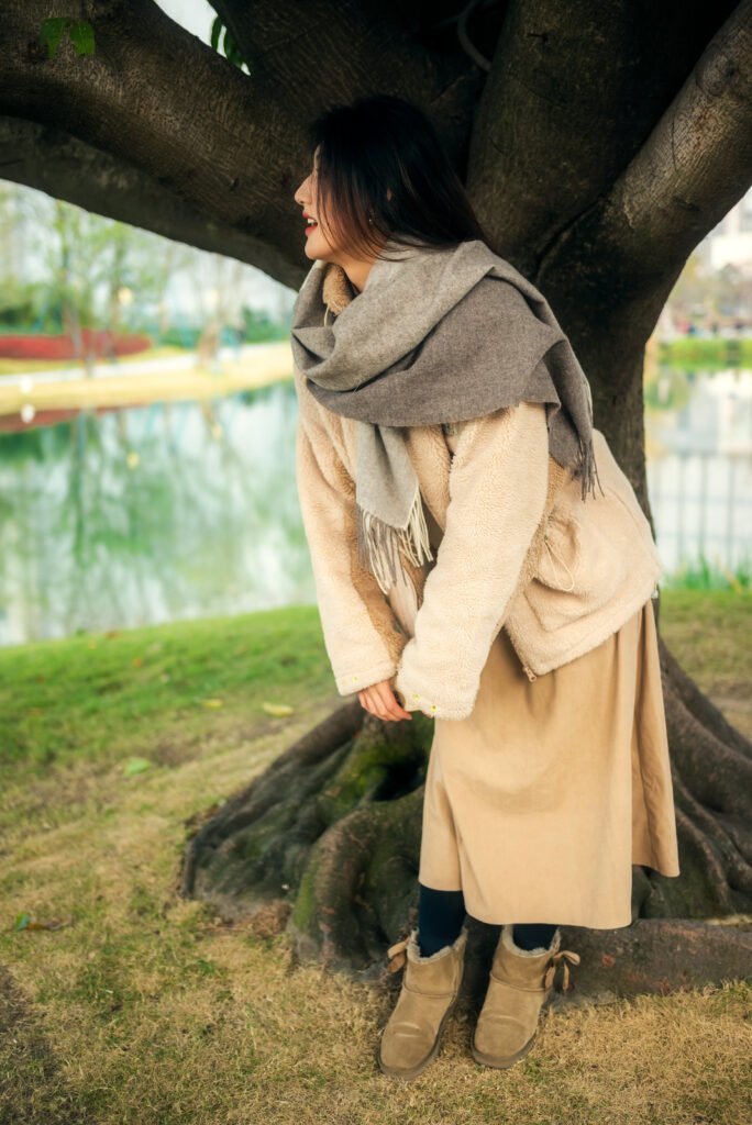 Portrait of a young woman standing by a tree