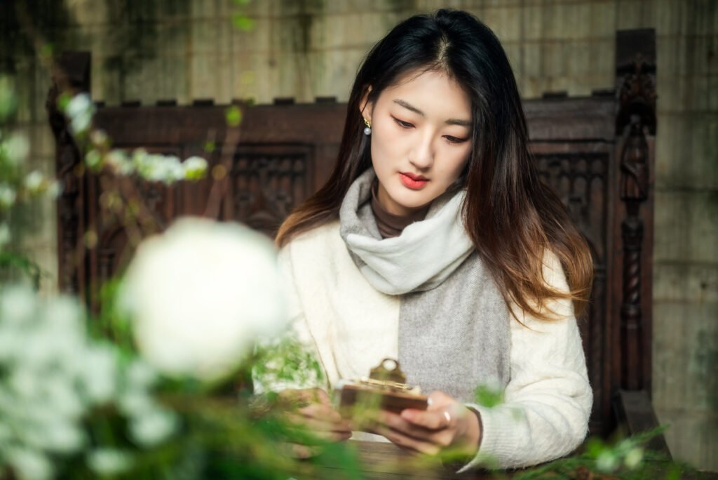Young woman sitting on a chair and reading a book.