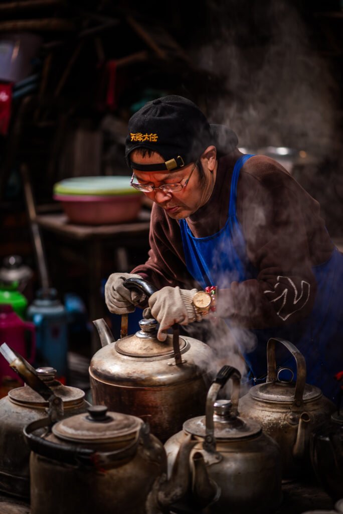 Man pouring hot water from a kettle.