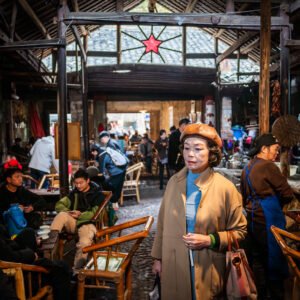 Elderly woman walking through a busy Chinese ancient tea house