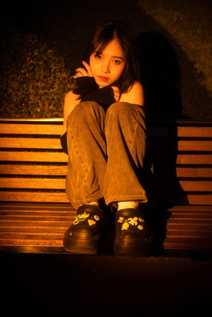 Lonely girl sitting on a bench at night