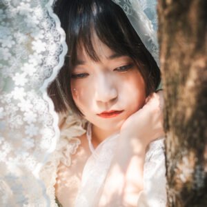 Beautiful Asian woman in a white dress standing in the forest