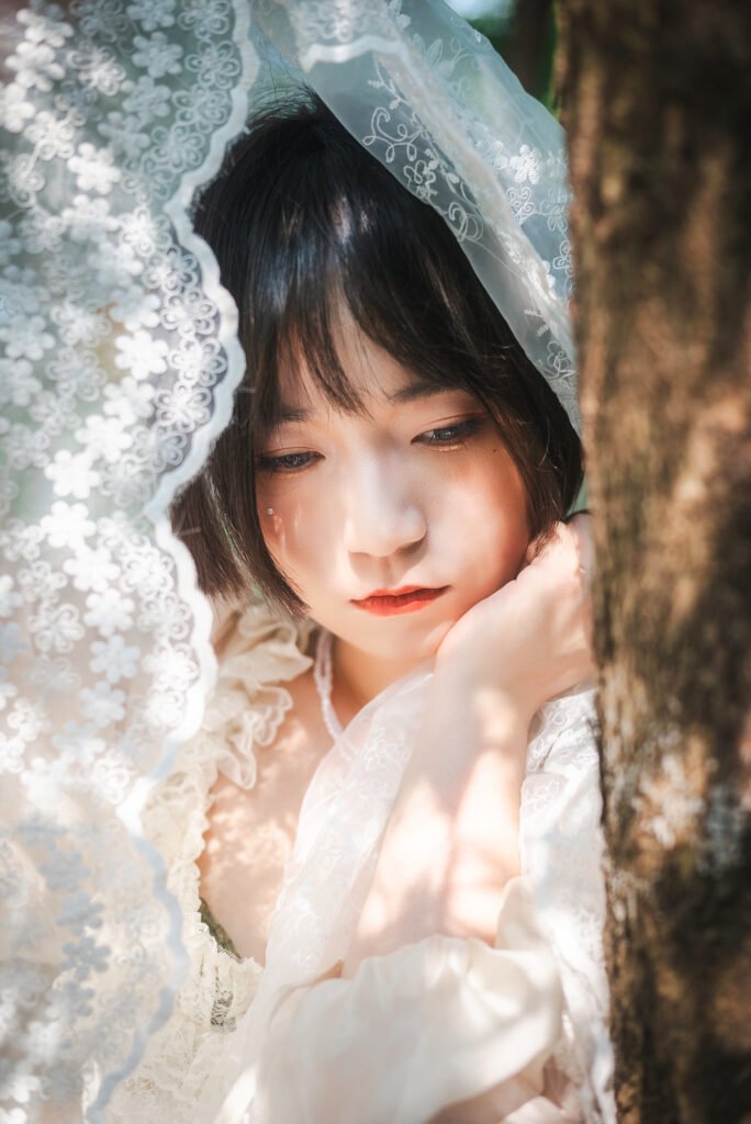 Beautiful Asian woman in a white dress standing in the forest