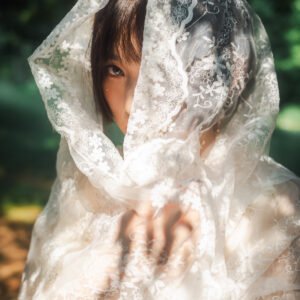 Mysterious woman hiding behind a white veil