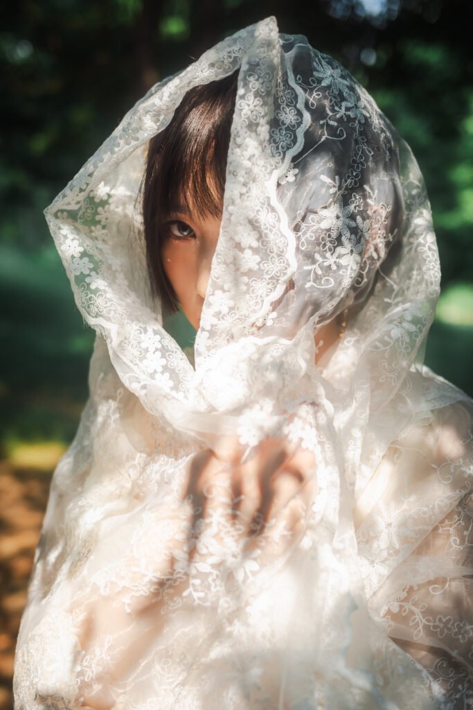 Mysterious woman hiding behind a white veil