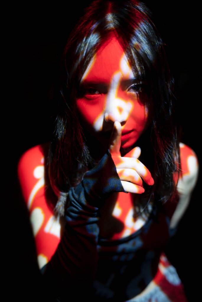 Young Asian woman posing at night in an red and white light