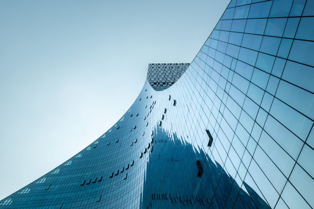 Modern curved glass building against clear blue sky