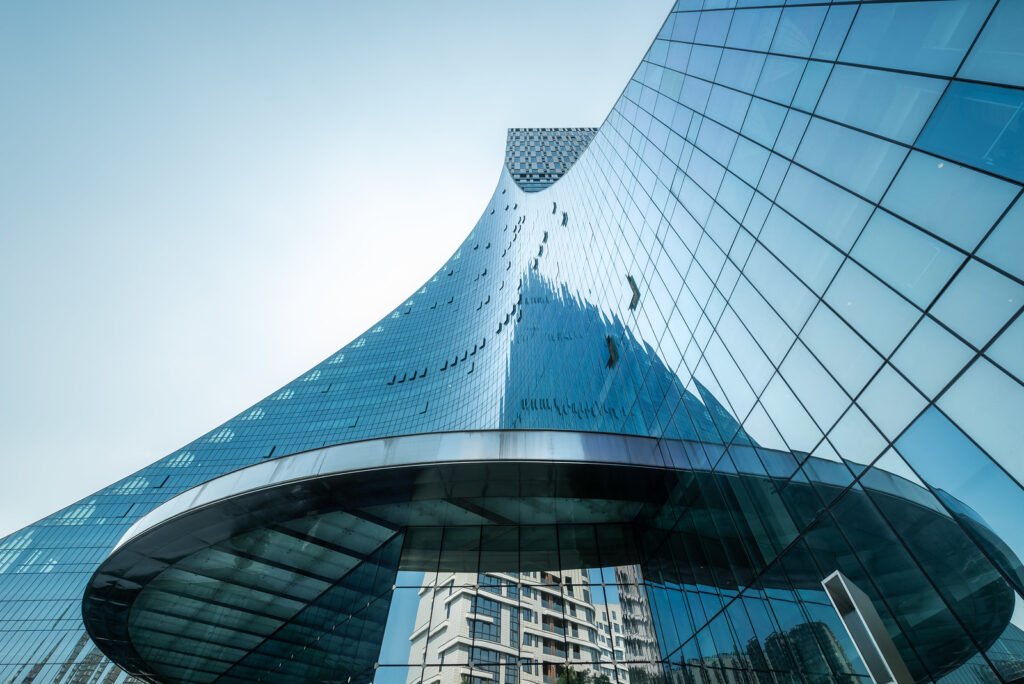 Modern curved glass building against clear blue sky