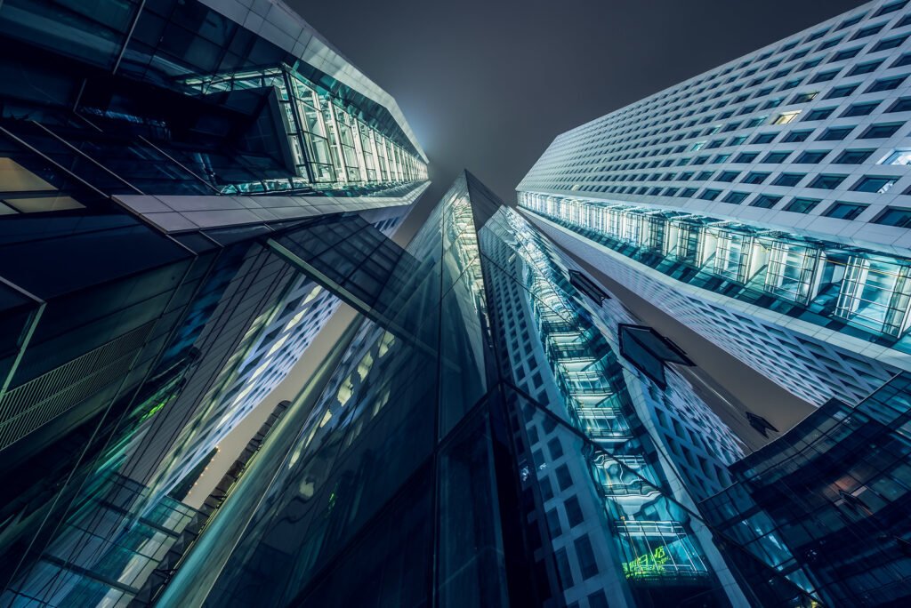 Modern skyscrapers illuminated at night against sky