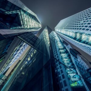 Modern skyscrapers illuminated at night against sky