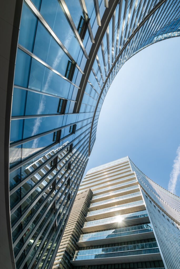 Modern curved glass buildings against clear blue sky