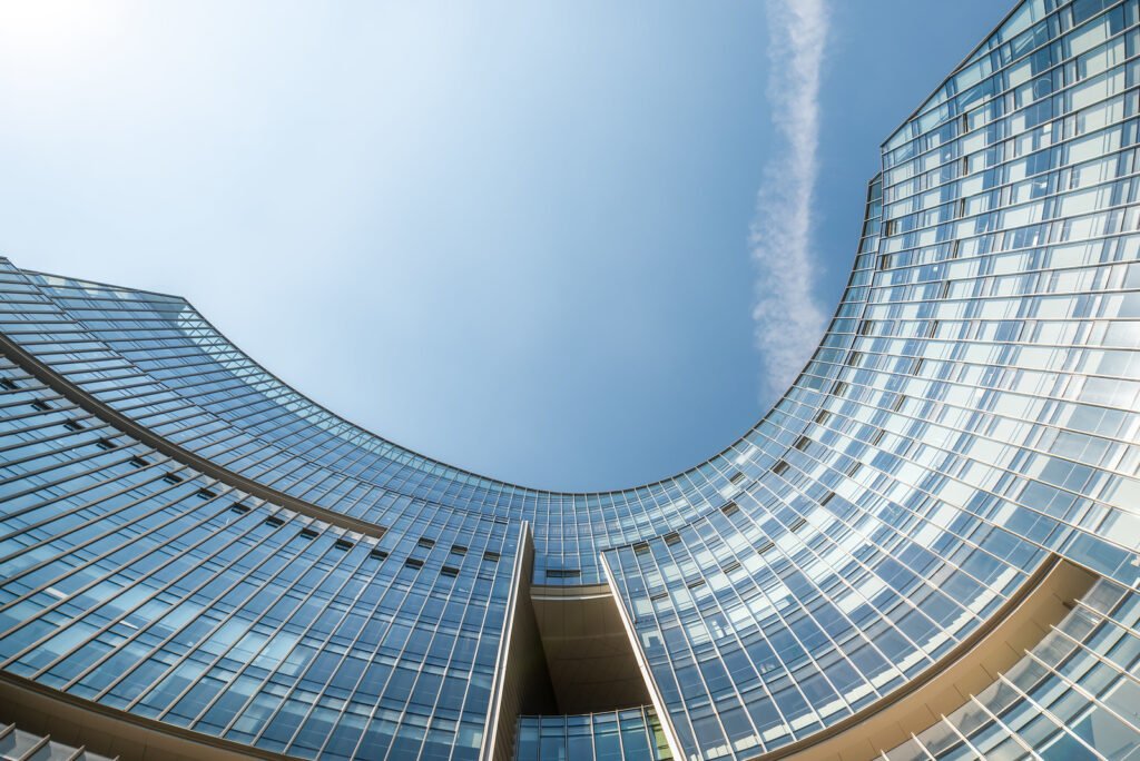 Modern curved glass buildings against clear blue sky