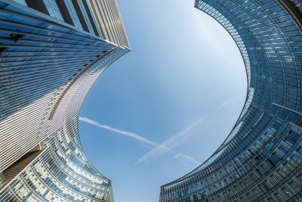 Modern curved glass buildings against clear blue sky