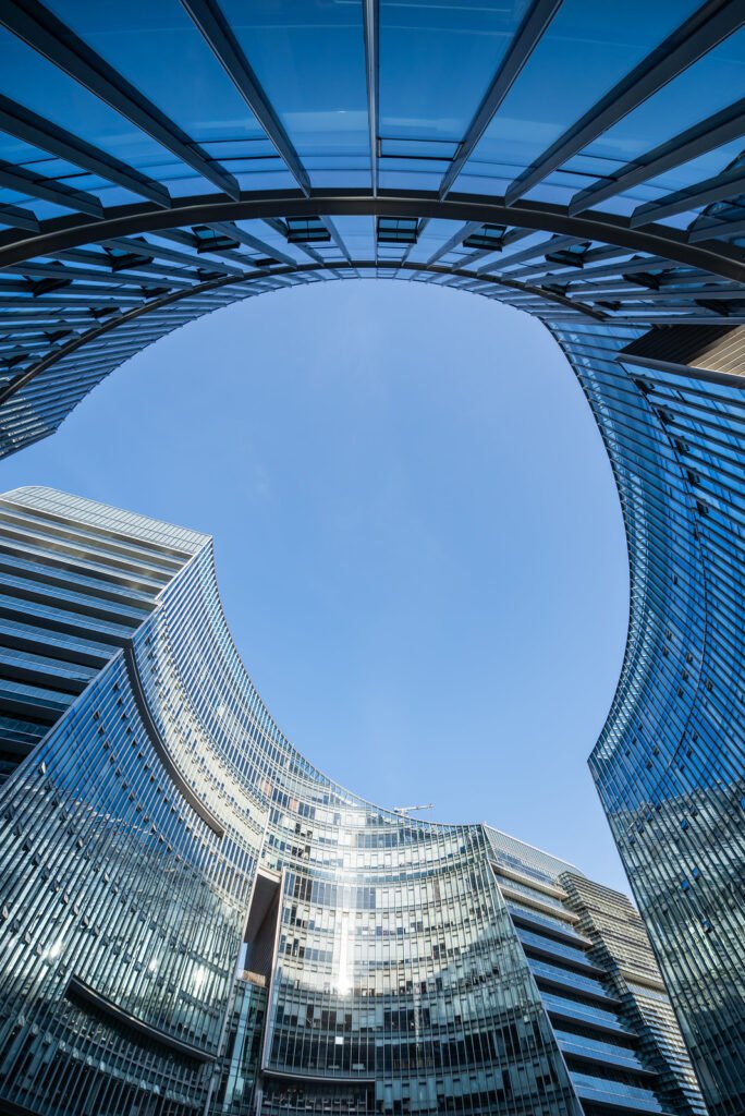 Modern curved glass buildings against clear blue sky