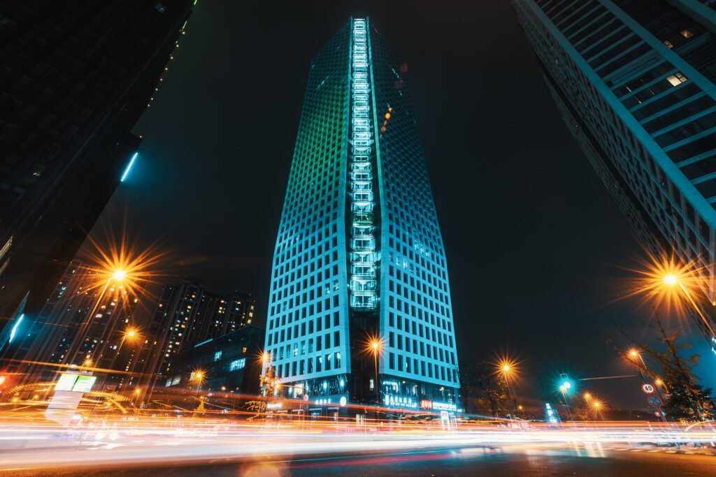 Car light trails on a crossroads surrounded by skyscrapers