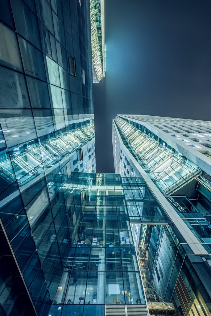 Modern skyscrapers illuminated at night against sky