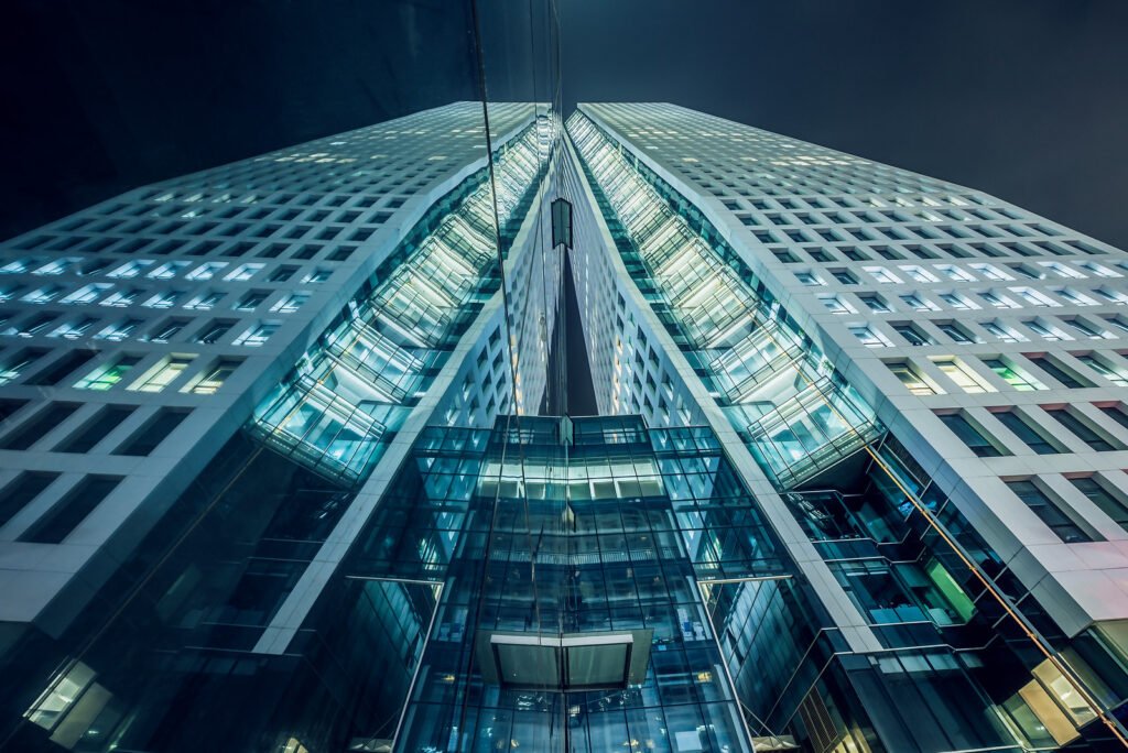 Modern skyscrapers illuminated at night against sky