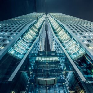 Modern skyscrapers illuminated at night against sky