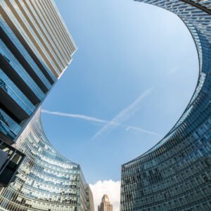 Modern curved glass buildings against clear blue sky