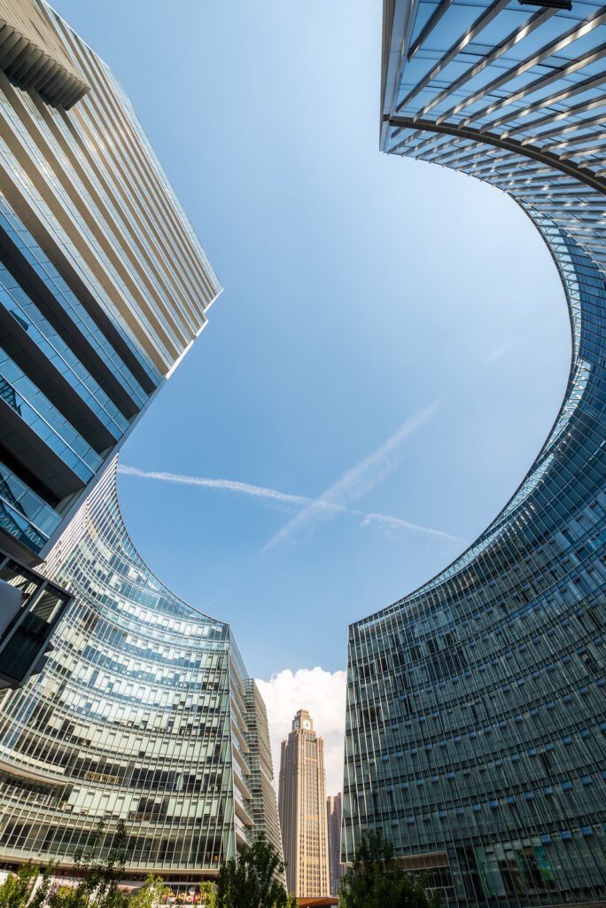 Modern curved glass buildings against clear blue sky