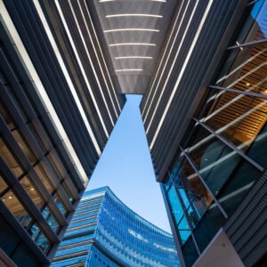 Illuminated modern curved skyscrapers against clear blue sky at dusk